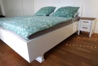 Doppelbett aus wei&szlig; lackiertem Massivholz mit angebautem Kopfteil